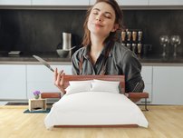 fototapeta na stenu mlada zenasediaca v kuchyni pri jedle 1